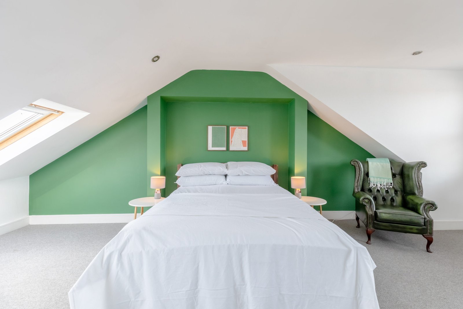 Property photo of a bedroom with a double bed with white sheets, on a top floor of a house, a bright green painted wall.