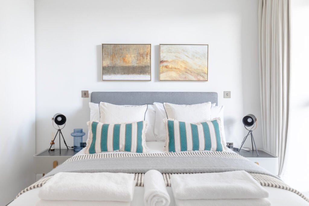 A modern decorated bedroom for Airbnb photography, white walls, double bed from front.