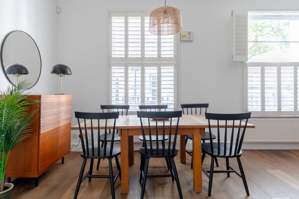 A wooden dining table with black wooden dining chairs, photo taken for airbnb photography