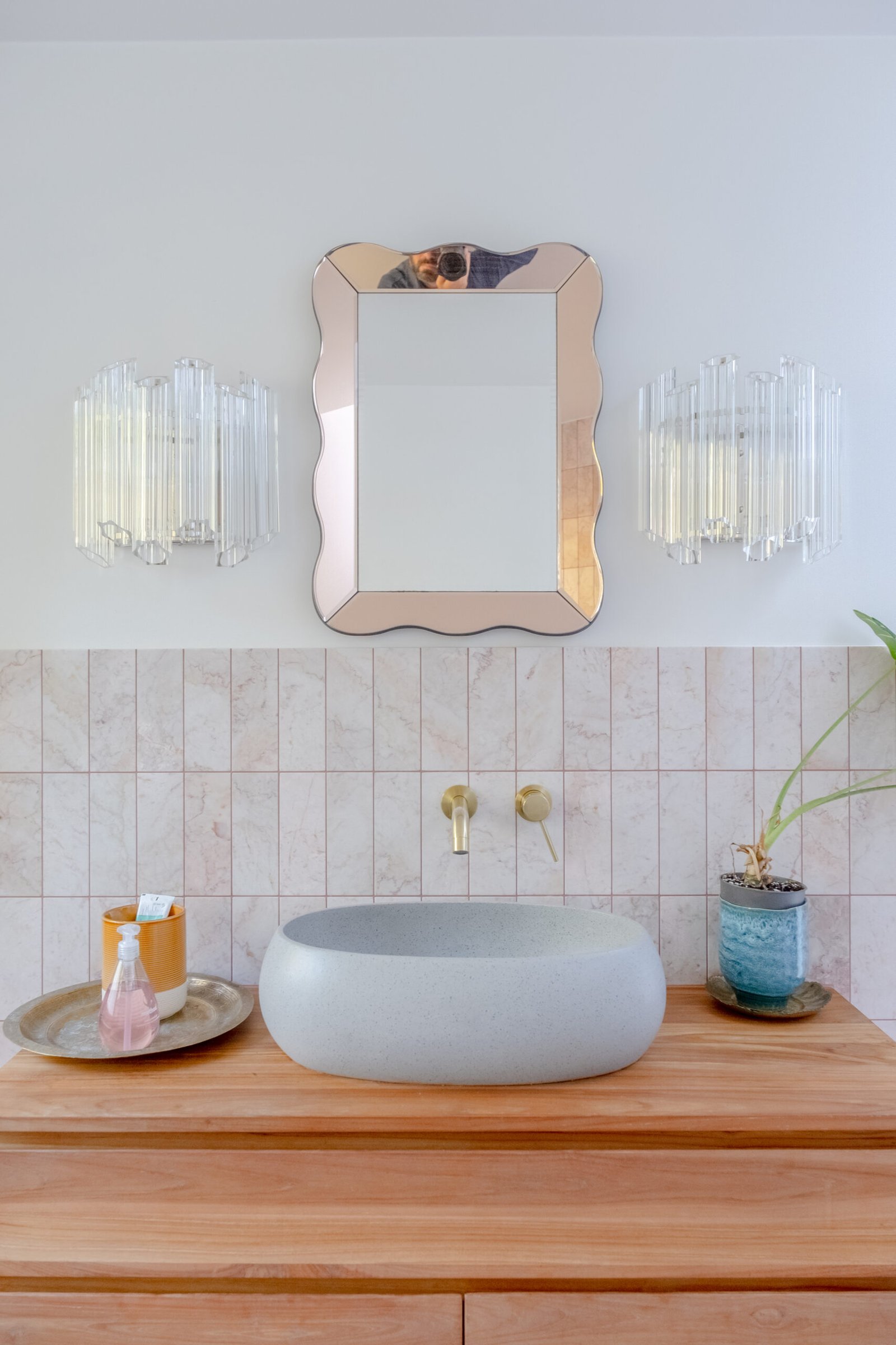 A modern bathroom sink and mirror photo, with a stone sink.