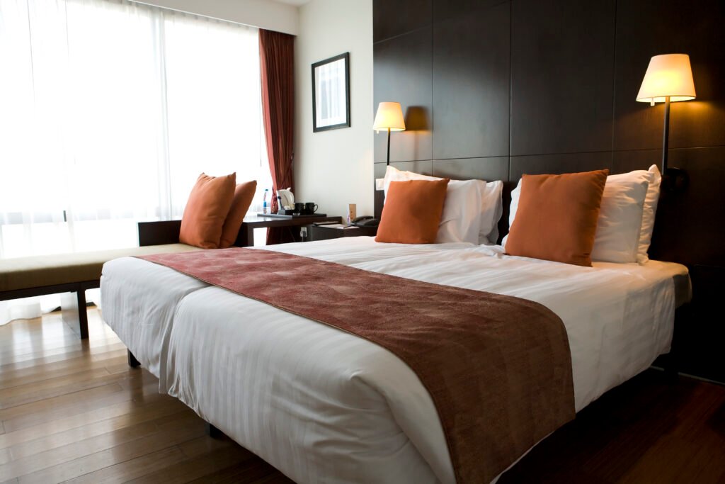 Modern designed hotel room with beds and nice decorated with warm colours.
