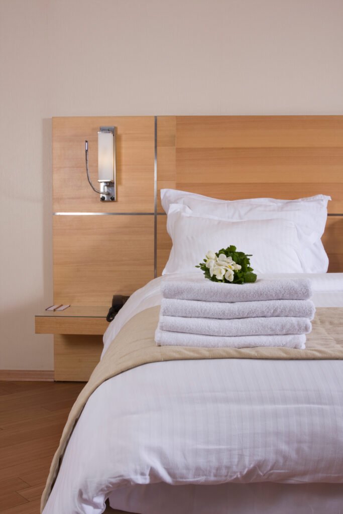 Vertical image of a bed in a hotel room, photo taken for hotel photography.