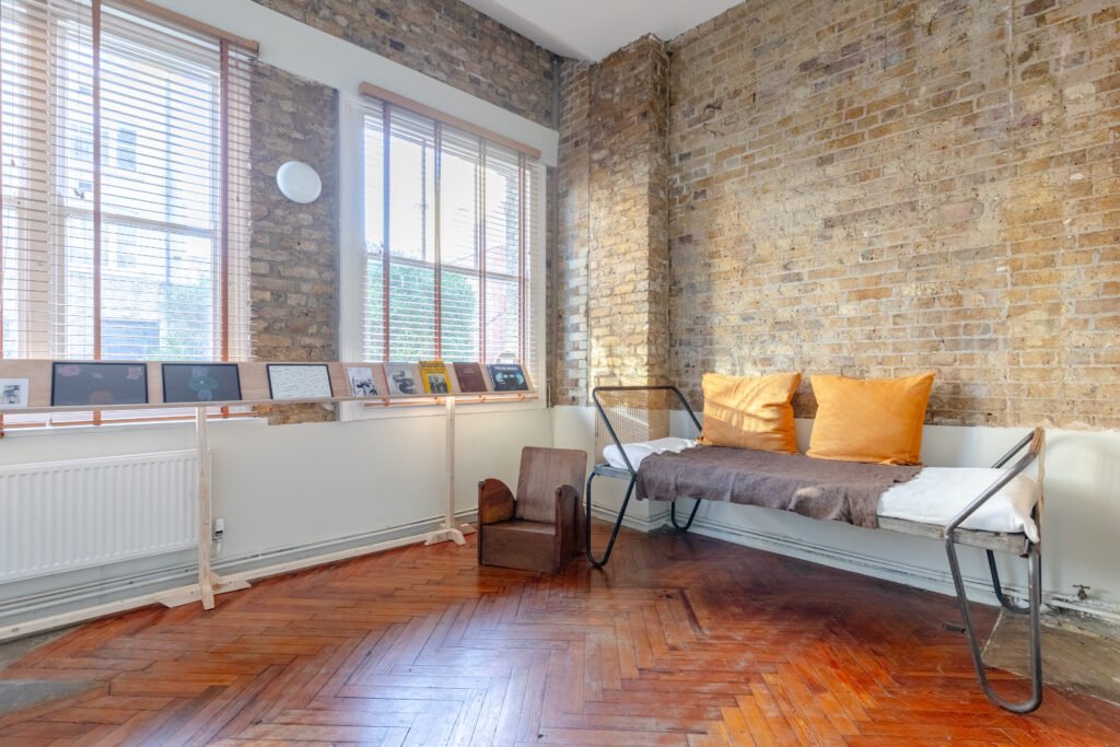Brick wall and a sofa in a large reception room captured for property photography.